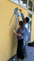 2 Personen malen an die Wand