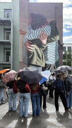 Schülergruppe schaut sich Graffitis an Häuserwand an